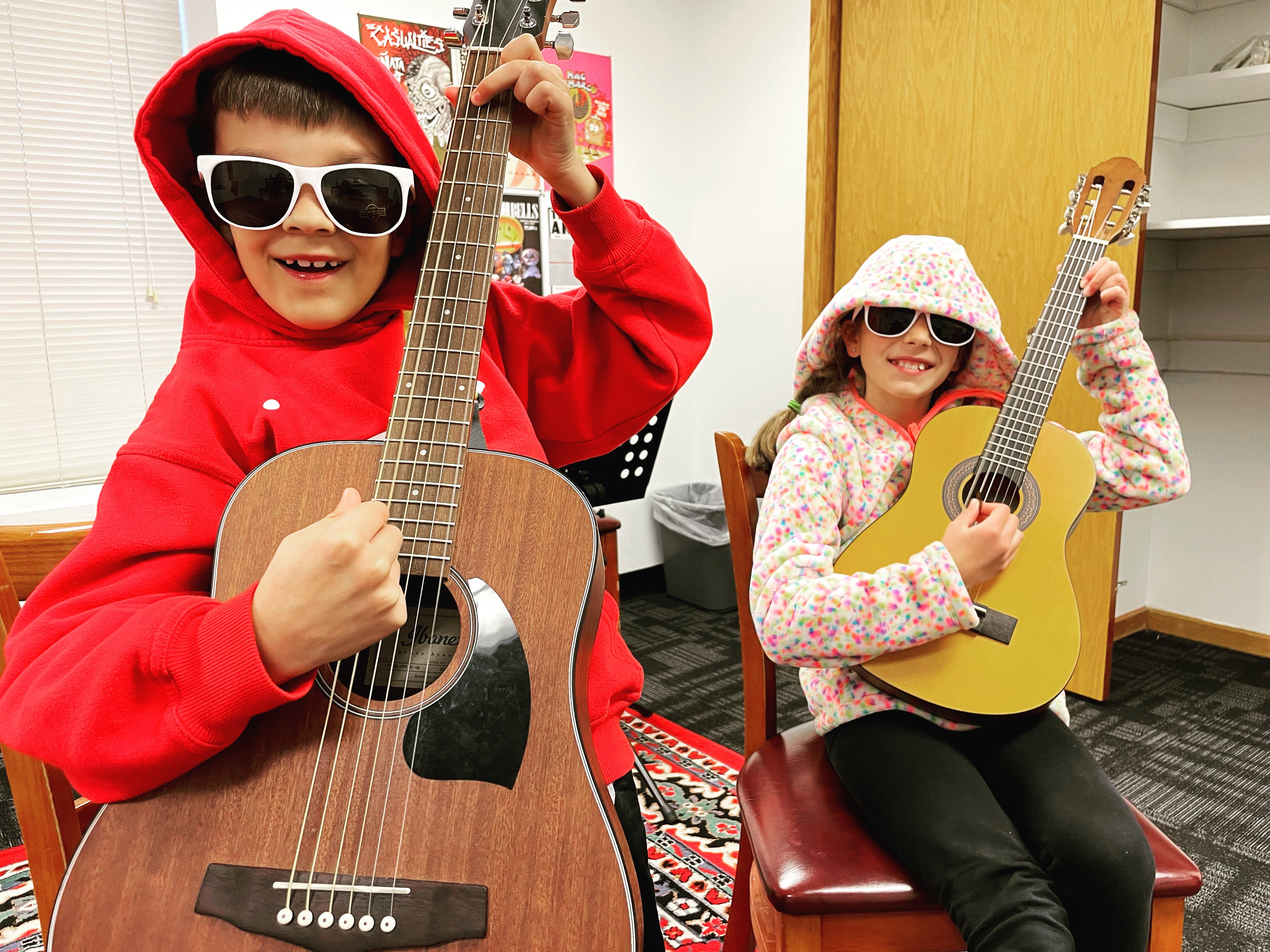 Two kids taking guitar lessons for kids