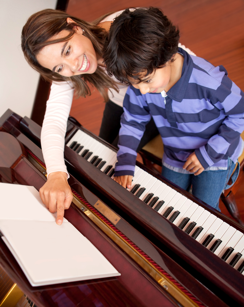 Young boy taking piano lessons 